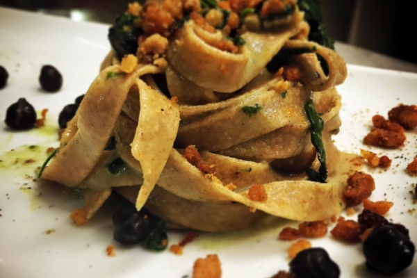 Fettuccine di farro con ceci neri, spinaci saltati e ciccioli di maiale