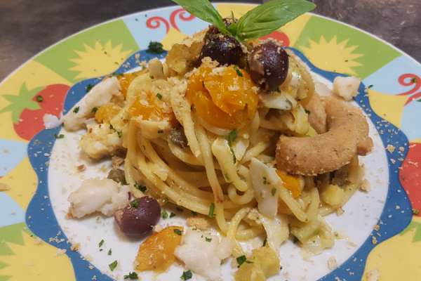 Spaghetti al baccalà con pomodorini gialli e taralli