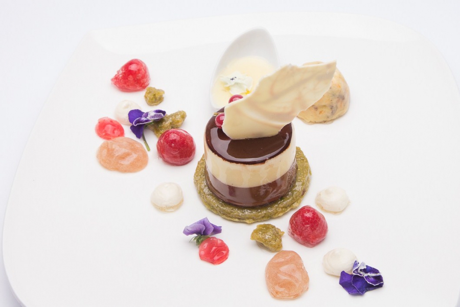 Dessert al cioccolato con biscotto al pistacchio, tortino alle pere e bergamotto e macedonia